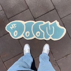 someone is standing on the sidewalk with their feet up in front of a blue and white rug