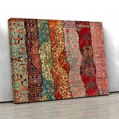 a multicolored rug on the floor in front of a white wall