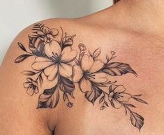 a woman's shoulder with flowers on it and leaves around the neck, in black ink