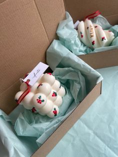 two white ceramic ornaments are in a box