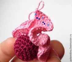 a small crocheted object in the palm of someone's hand