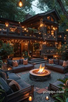 a fire pit surrounded by couches and lights in front of a large house with lots of windows