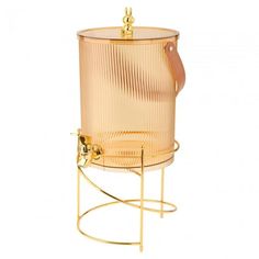 a gold colored beverage dispenser on a stand with a leather strap around the handle