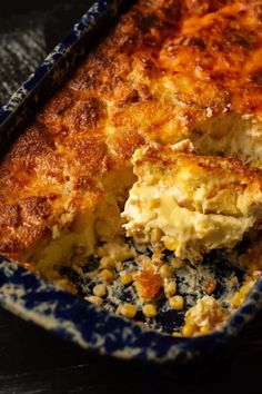 a casserole dish with corn and cheese in it on a black table top