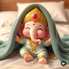 an elephant figurine sitting on top of a bed covered in a blue blanket