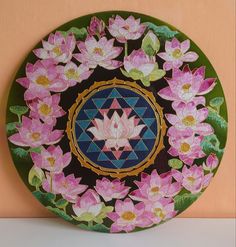 a plate with flowers painted on it is sitting on a table next to a wall