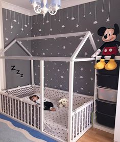 an image of a bedroom with mickey mouse on the wall and other items hanging from the ceiling