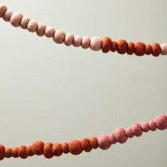 some pink and orange beads hanging from a string