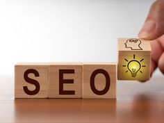 the word seo spelled out with wooden blocks and a lightbulb in front of it