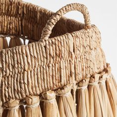 a large woven basket with tassels on it