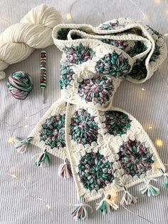 two crocheted bags sitting on top of a bed next to yarn