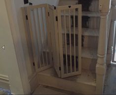 a baby gate sitting in the corner of a room next to a stair case and window