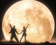 two people holding hands in front of a large full moon with the silhouettes of dancers