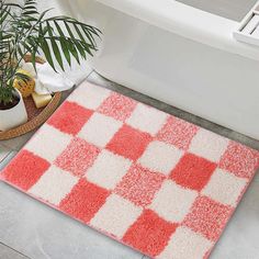 a red and white rug on the floor next to a bath tub