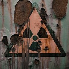 a sign that is on the side of a metal wall with peeling paint and rust