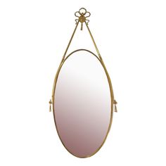 an oval mirror hanging on the wall with a gold frame and metal barbwire