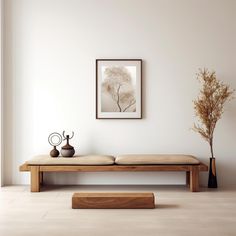 a wooden bench with two vases on it in front of a white wall and floor