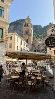 an outdoor cafe with tables and chairs on the street