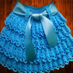 a blue crocheted skirt with a bow on it