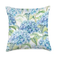 a blue flowered pillow on a white background with green leaves and watercolor flowers