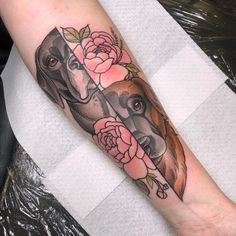 a dog and rose tattoo on the arm