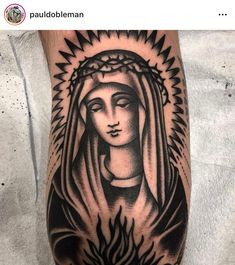 a black and white tattoo on the arm of a person with a virgin mary in flames