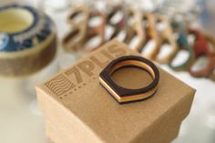 a wooden ring sitting on top of a cardboard box next to other rings in the background