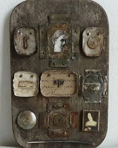 an old wooden plaque with pictures and other items attached to the back of it on a white wall