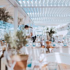 a woman is cleaning the tables at an outdoor restaurant