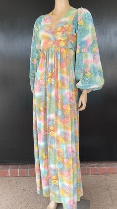 1970s maxi dress. Predominantly green multicolor silky nylon or polyester. Empire waist. Tie belt attached on front wraps to back to tie. Skirt gathered only under front belt. Sleeves have elastic cuffs. Nylon zip back. Measurements are  32" bust 24" waist Up to 50" hips 14" bodice length 59" length 28" sleeves 10" shoulders Pretty dress presents well exhibiting very minimal to no obvious wear. Vintage Green V-neck Maxi Dress, Retro Green Floral Print Maxi Dress, 1970s Style Multicolor Maxi Dress, Multicolor Long Sleeve Maxi Dress, Flowy Retro Maxi Dress, Green Retro Maxi Dress With Floral Print, Retro Green Long Sleeve Maxi Dress, Green Long Sleeve Retro Maxi Dress, Green Vintage V-neck Maxi Dress