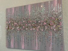 a painting with pink and silver glitters on the side of a wall next to a white wall