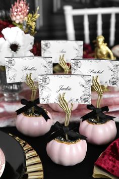 place cards are placed on small pumpkins with black bows and gold accents for centerpieces