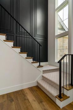 an empty staircase with black walls and white carpet