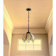 a chandelier hanging from the ceiling in a room with a door and window