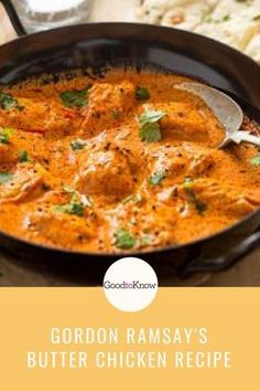 a pan filled with chicken curry on top of a wooden table