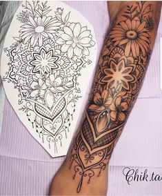 a woman's arm with flowers and hearts on it, next to a coloring book