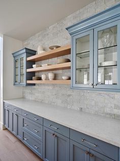 a kitchen with blue cabinets and marble counter tops