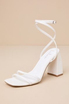 a white high heeled sandal with an ankle strap