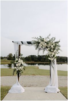 an outdoor ceremony setup with white flowers and greenery