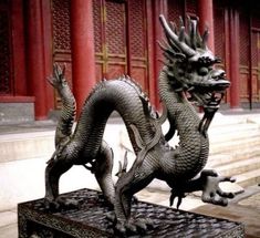 a statue of a dragon in front of a building