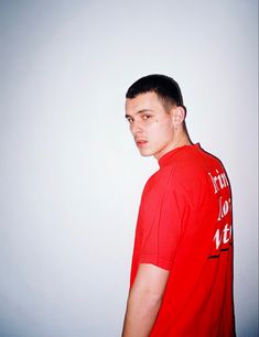 a young man in a red shirt is posing for the camera