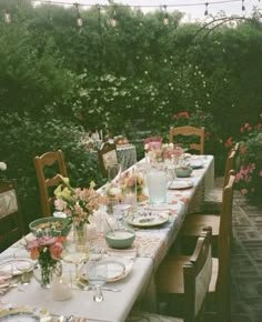 a long table with plates and glasses on it in the middle of an outdoor patio