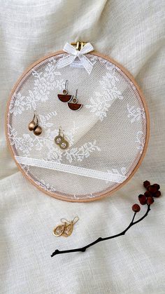 an embroidery hoop with several earrings on it