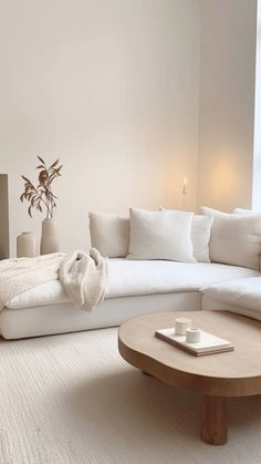 a living room filled with white furniture and pillows