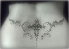 the back of a woman's stomach with an intricate design on her lower back