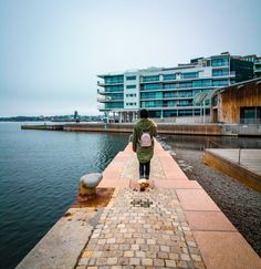 a person walking down a sidewalk next to the ocean with text overlay reading how to spend one full day in norway's capital