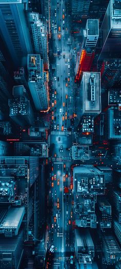 an aerial view of a city street at night with traffic lights and skyscrapers in the background