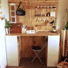 a wooden desk topped with lots of drawers next to a shelf filled with pots and pans