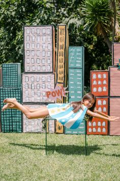 a woman laying on top of a chair in the grass with her legs spread out