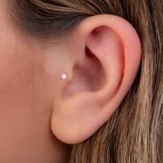 a woman's ear with a tiny white dot on it